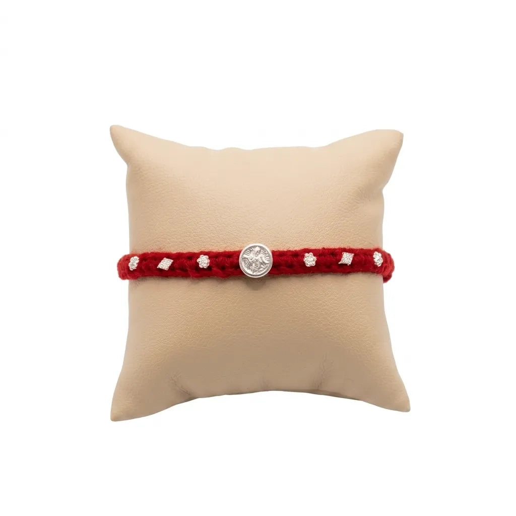 Marvel Silver Satvik Rakhi with spiritual silver-finish centerpiece, handcrafted red thread, and elegant silver embellishments for Raksha Bandhan.