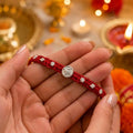 Marvel Silver Satvik Rakhi with spiritual silver-finish centerpiece, handcrafted red thread, and elegant silver embellishments for Raksha Bandhan.