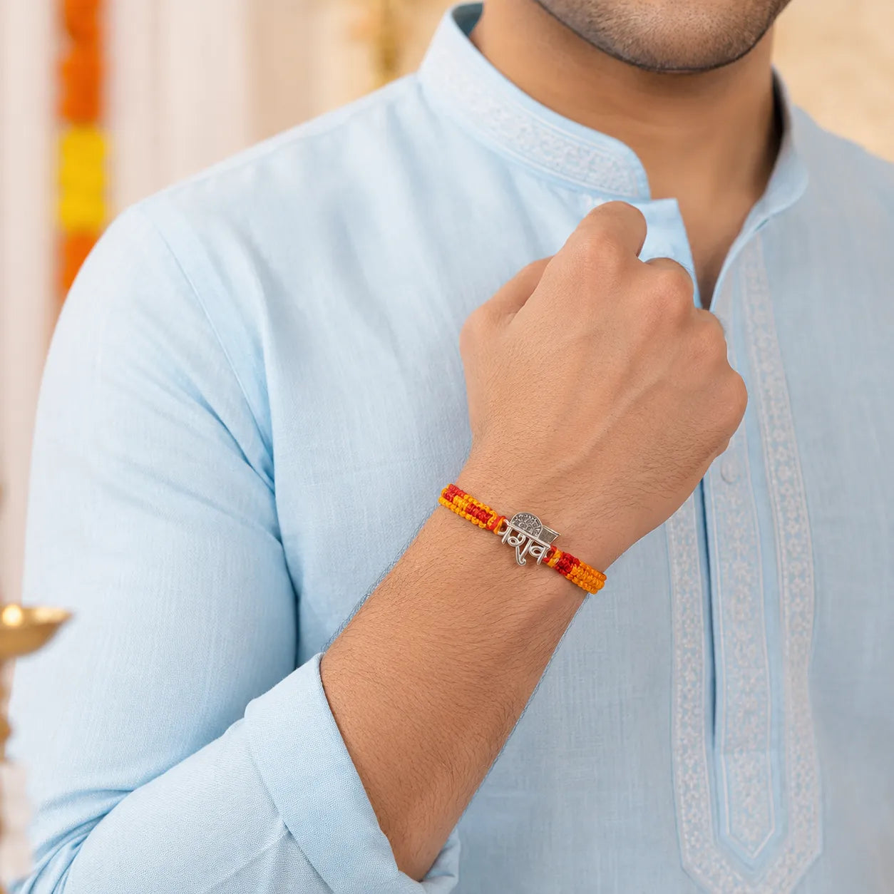 Marvel Silver Shiv name rakhi for brother with yellow red braided thread and silver-tone devotional centre motif