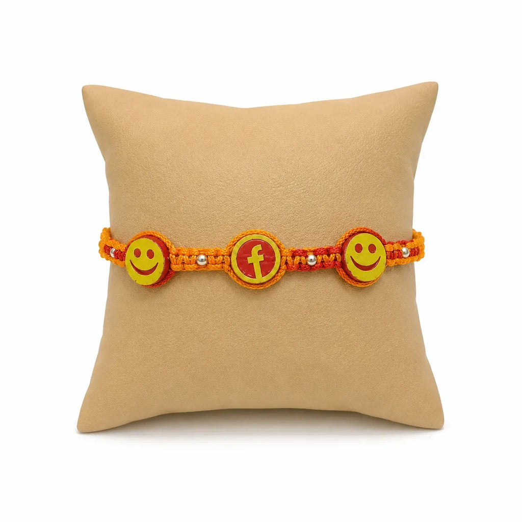 Marvel Silver Smiley Face Designer Rakhi with two smiley charms, center letter charm, silver-tone bead accents, and orange-red braided thread for Raksha Bandhan.