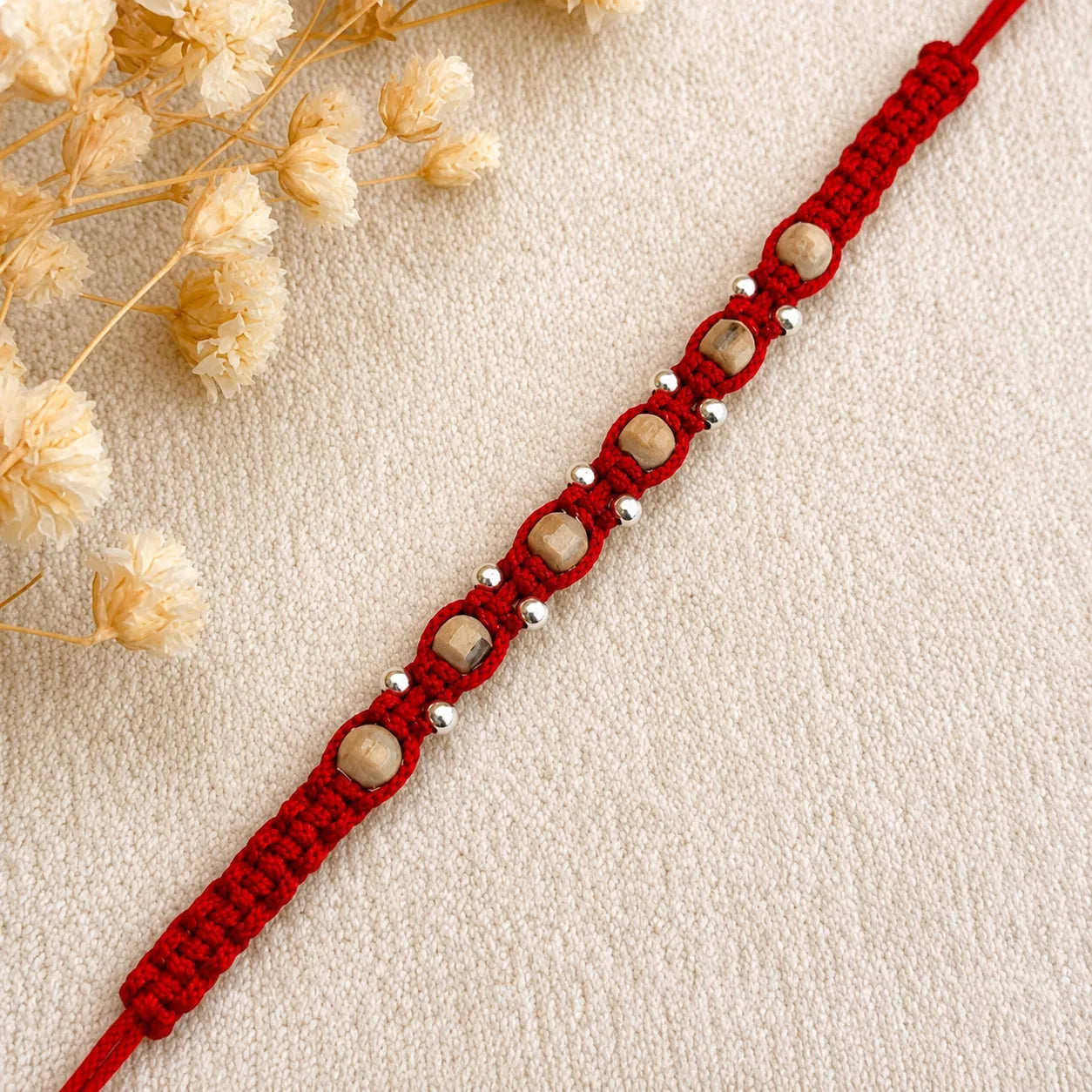 Marvel Silver square bead rakhi for brother with red braided thread, beige square beads and silver-tone accents