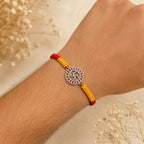 Marvel Silver Swastik motif rakhi for brother with yellow braided thread and silver-tone circular centre charm