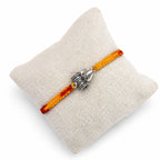 Marvel Silver Trishul Damru design rakhi with yellow red braided thread and silver-tone devotional charm