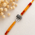 Marvel Silver Trishul Damru design rakhi with yellow red braided thread and silver-tone devotional charm