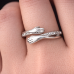 Silver hugging hands with stone band