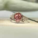 Pink pear-cut center, side stones