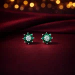 •Vibrant floral stud earrings with a central clear stone surrounded by a "petal" halo of deep emerald-green gemstones.