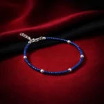 •A delicate blue beaded bracelet interspersed with small silver-toned spheres and an adjustable chain clasp.