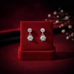 •Elegant silver-toned drop earrings with a floral-inspired design and central clear sparkling stones.